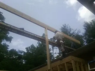 Carpenter setting a ridge beam over a new addition frame — Ice Dam Removal by Roofing Brothers in Black Earth