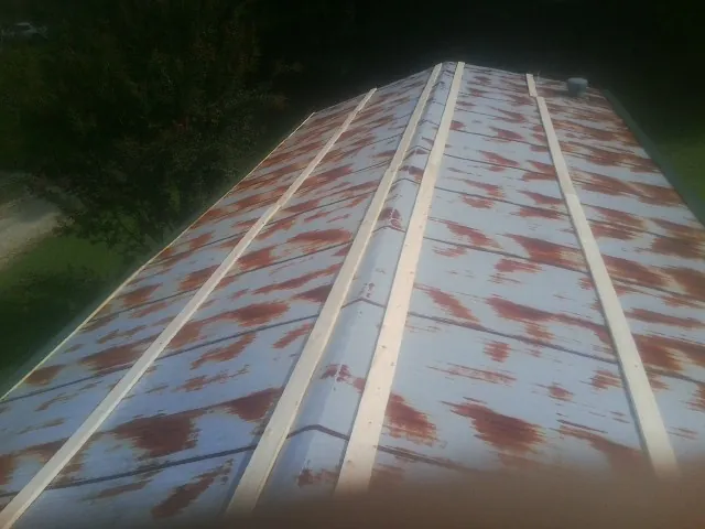 Rusted metal roof panels with new wood purlins before replacement — Storm Damage Roof Repair in Black Earth by Roofing Brothers