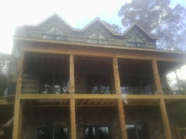 Dormers and porch framing on a large log home under construction — Roof Coating work by our crew in Black Earth