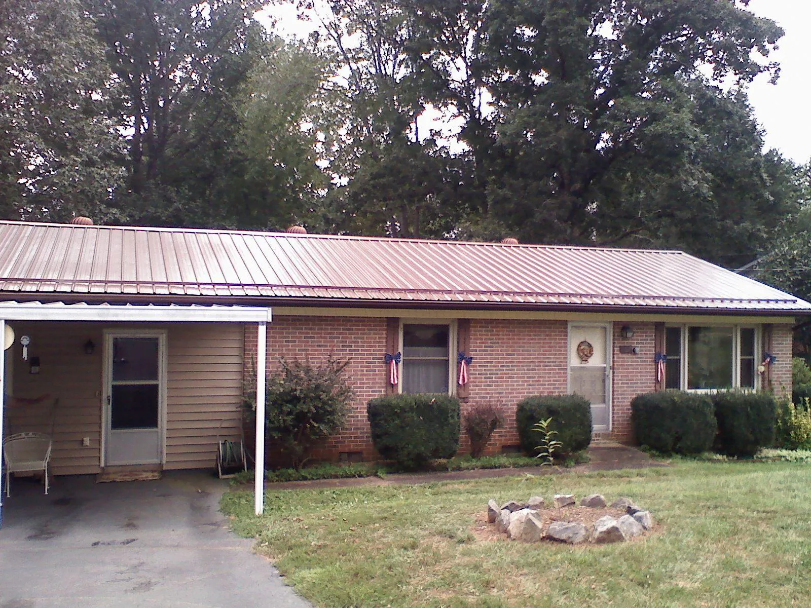 Bronze metal roof and carport on a brick ranch home — Roof Repair work by our crew in Black Earth